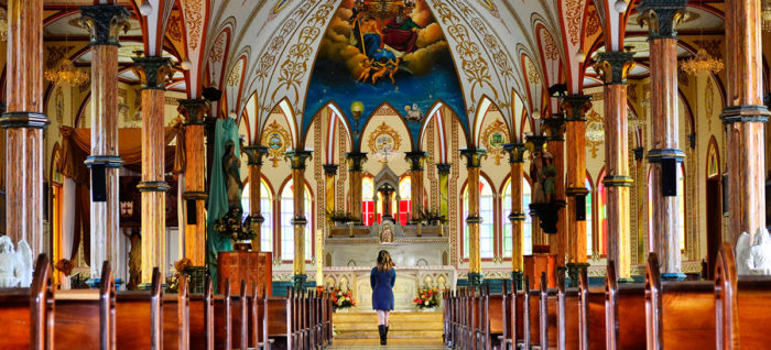 Young girl in front of beautiful church viewing the renovated alter made possible with church financing