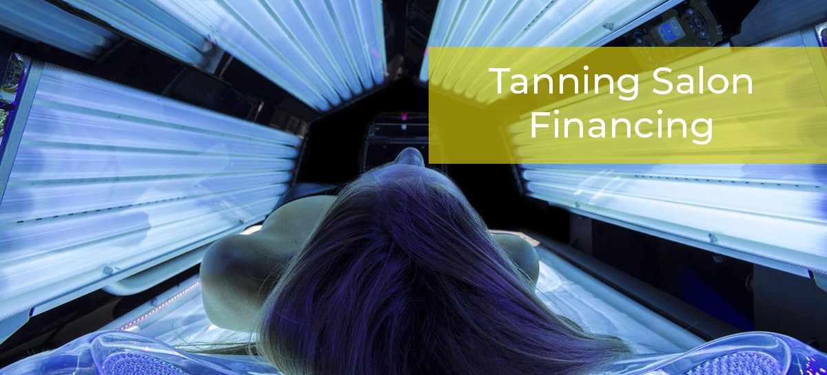 Woman laying on new tanning bed paid for with tanning salon financing