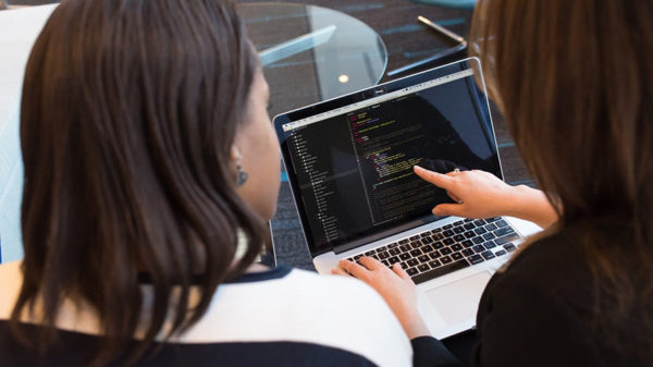 Two women looking at laptop establishing their startup's visual brand identity