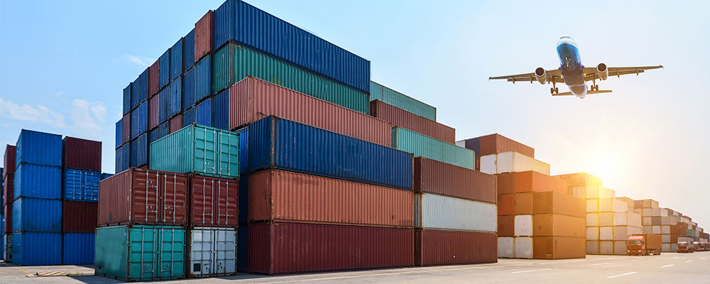 Plane flying over shipping containers