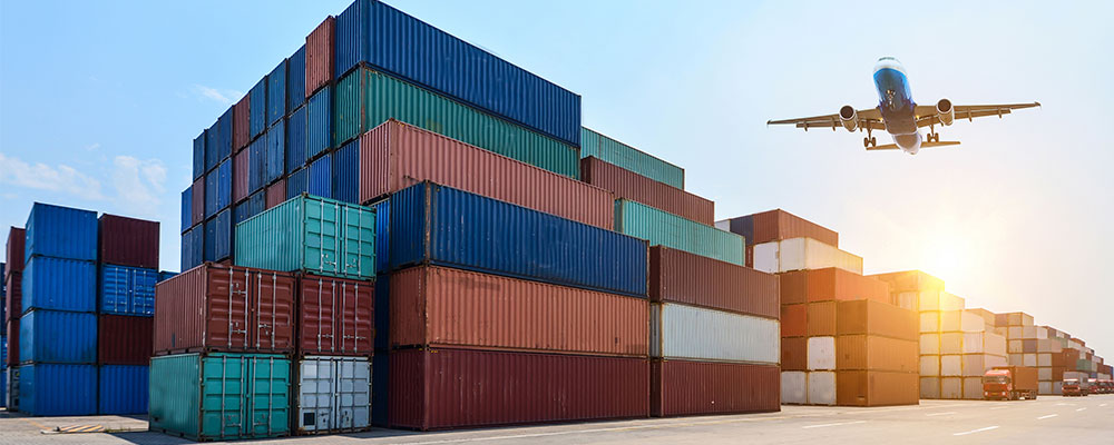 Plane flying over shipping containers